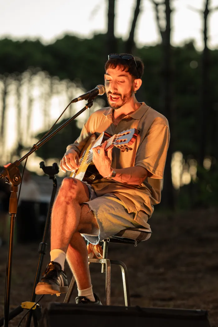 Músico tocando la guitarra en el bosque