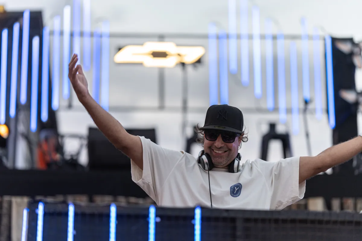 DJ con los brazos en alto en un escenario de marca